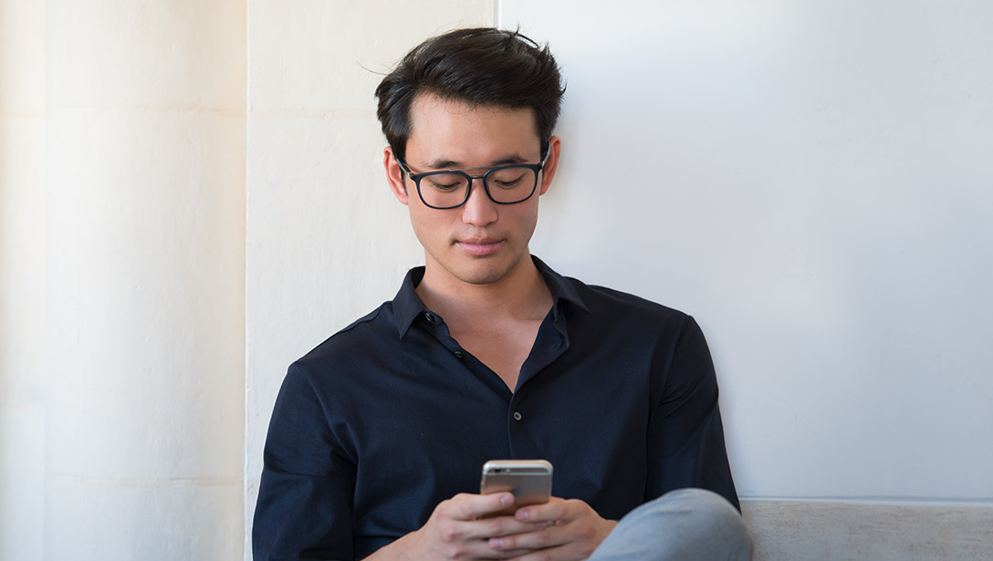Man with glasses looking at phone