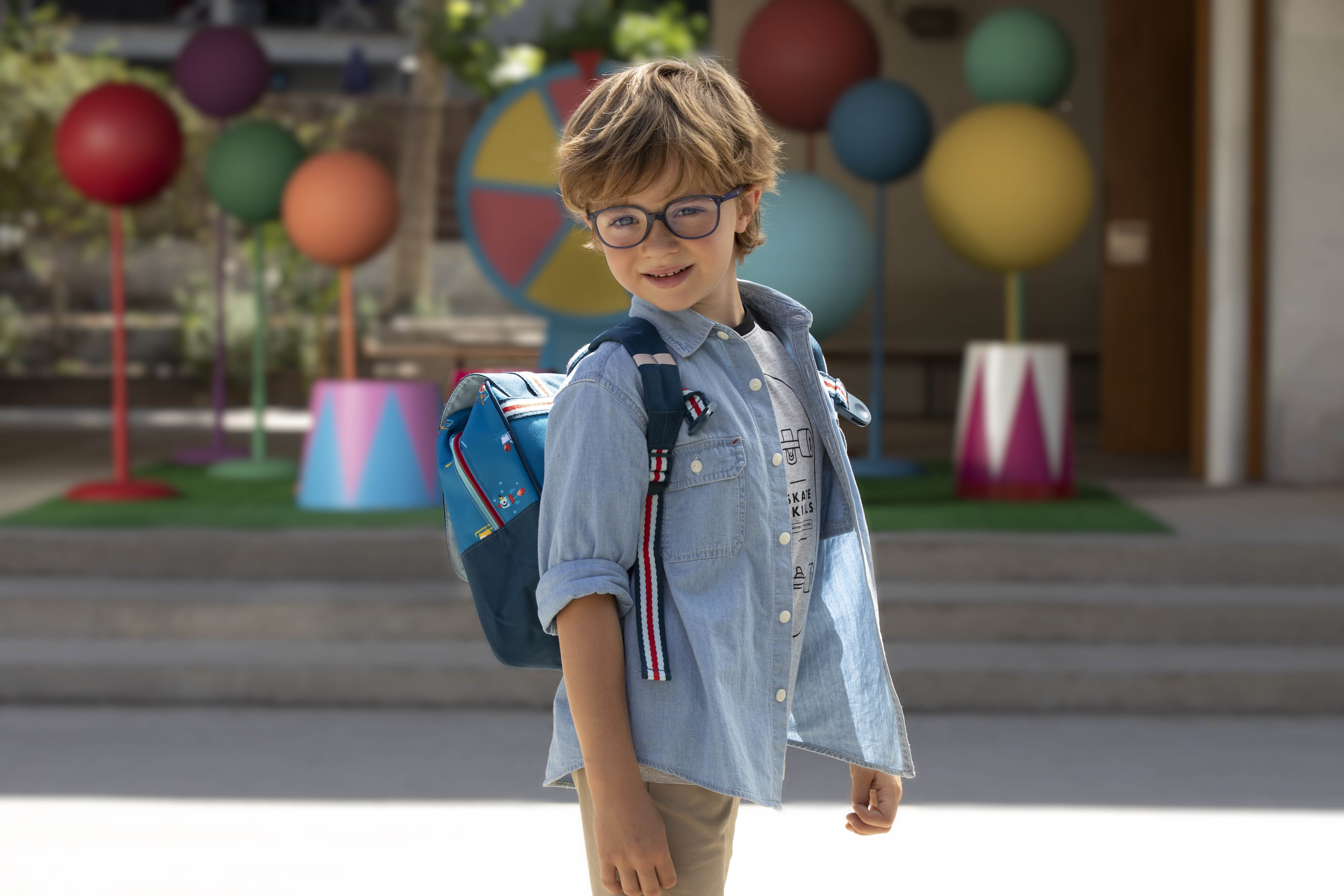 Child with a backpack wearing glasses